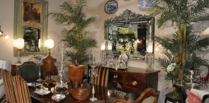 Dining room display Country French dining room with Sheraton mahogany table and antique sideboard, antique Louis XV walnut bergeres, Venetian mirror, and trumeau mirro